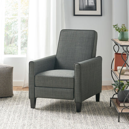Gray armchair in a living room setting with a window and decorative items.