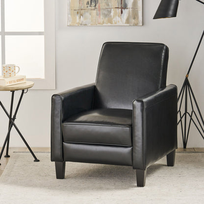 Black leather armchair in a room with a side table and lamp.