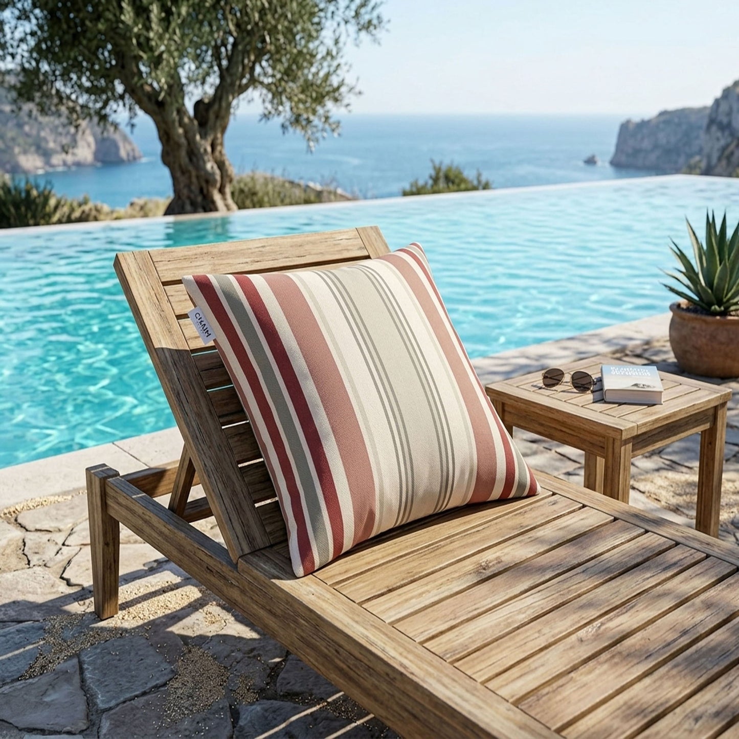 Wooden lounge chair with a striped pillow by a poolside with ocean view