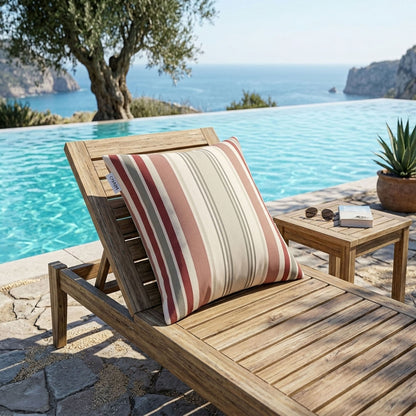 Wooden lounge chair with a striped pillow by a poolside with ocean view