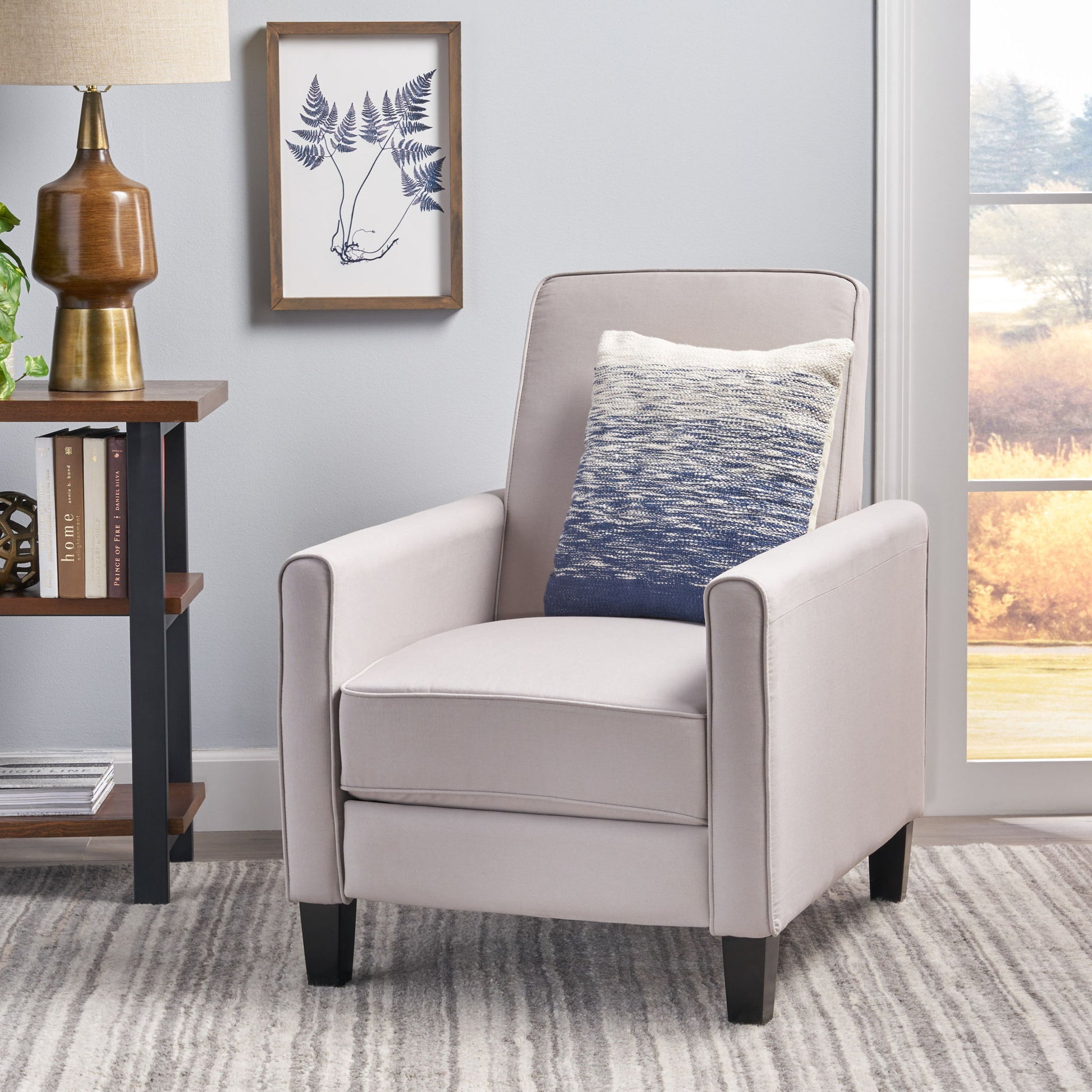 Gray armchair with a blue pillow in a living room setting